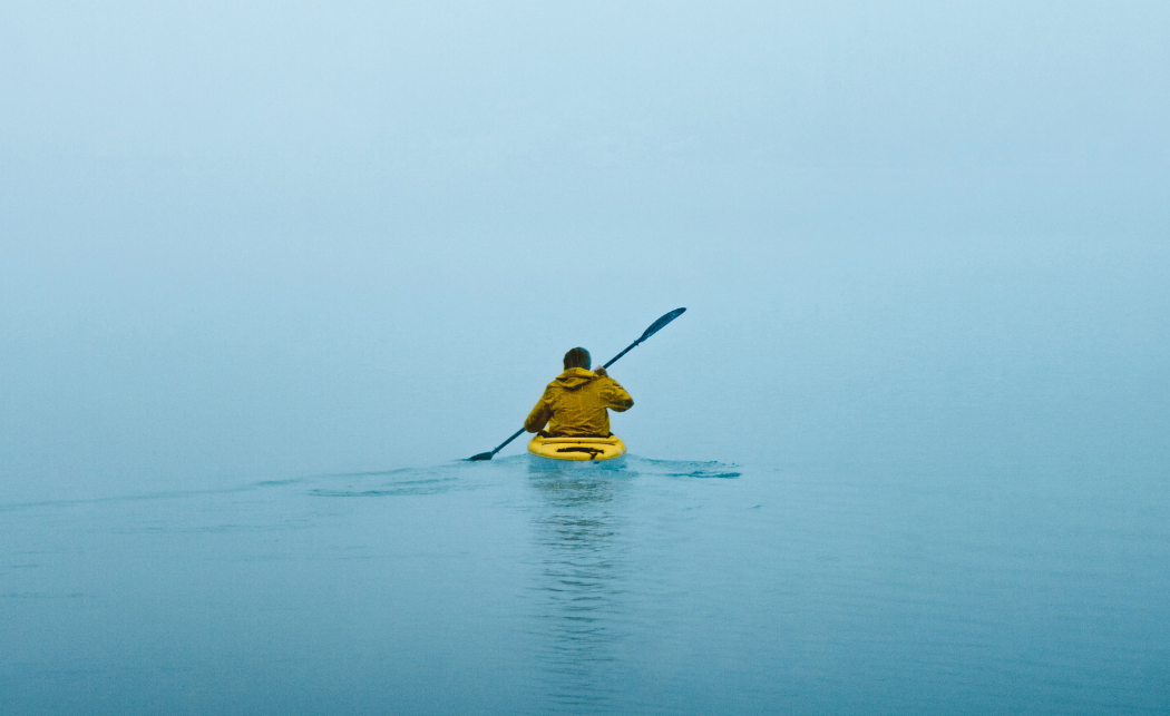 Person kayaking on the ocean, symbolizing the importance of reliable connected product management and IoT monitoring to prevent device drift.